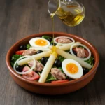 A vibrant, top-down shot of a classic ensalada mixta in a rustic terracotta bowl on a dark wooden table.